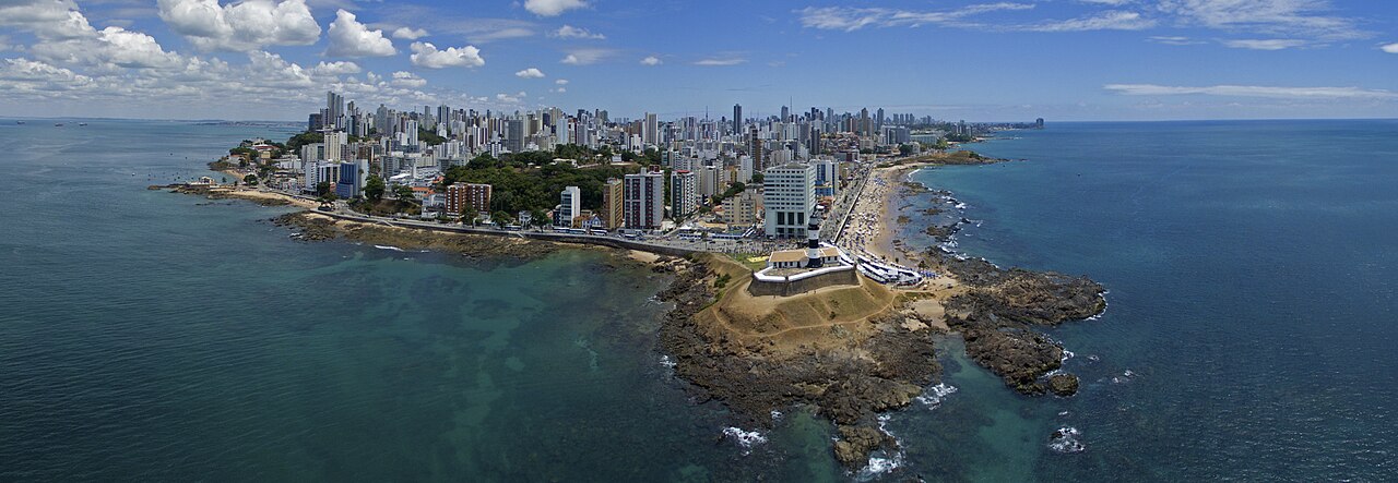 Vista aérea da orla de Salvador com o Farol da Barra e o oceano